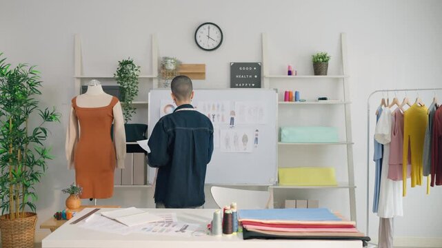 Caucasian young woman working as fashion designer in tailor studio. 