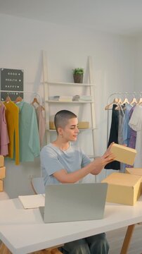 Caucasian woman checking customer orders on laptop in clothing store. 