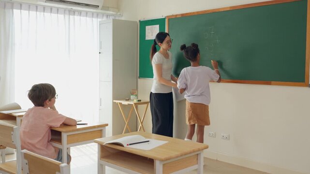 African American young student answering math problems in front of classroom. 