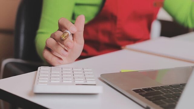 Close up with Start up small business, SME female owner using laptop checking order online to prepare to pack a box of goods for sale to customers, sme business idea.