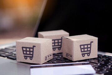 Shopping online. Credit card and cardboard box with a shopping cart logo on laptop keyboard. Shopping service on The online web. offers home delivery © Achira22