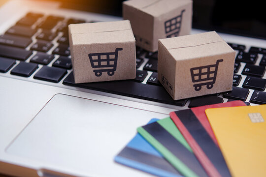 Shopping online. Credit card and cardboard box with a shopping cart logo on laptop keyboard. Shopping service on The online web. offers home delivery