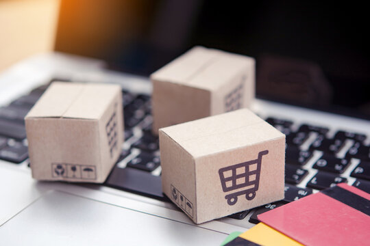 Shopping online. Credit card and cardboard box with a shopping cart logo on laptop keyboard. Shopping service on The online web. offers home delivery