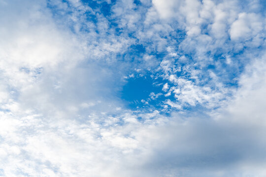 Bright blue sky filled with soft white cloud layer creates peaceful and tranquil atmosphere, bringing serene feeling through natural background outdoor weather scene view