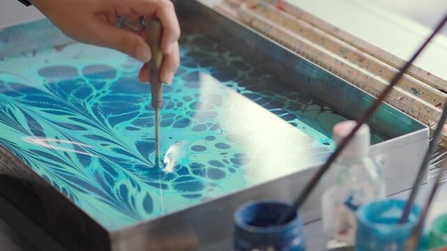 Artist Creating Ebru Marbling Art on Water Surface