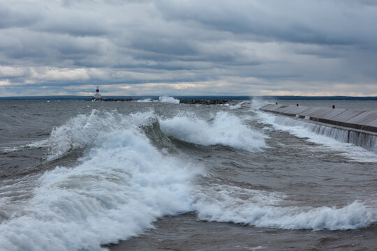 Lighthouse guiding through storm with crashing waves
