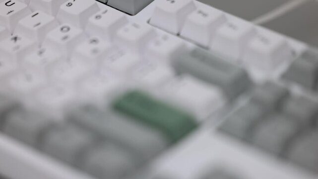 Mechanical keyboard with a green keycap in shallow depth of field