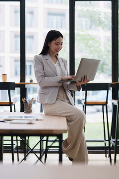 Asian businesswoman working on laptop in modern office