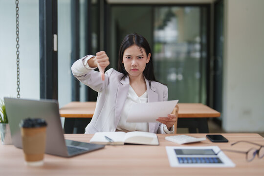 Businesswoman showing thumbs down expressing disapproval and rejection
