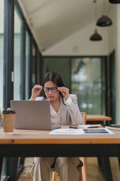 Businesswoman having eye strain and vision problems at office
