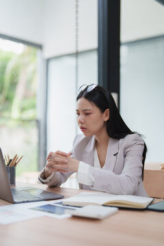Stressed businesswoman thinking and concentrating on laptop work