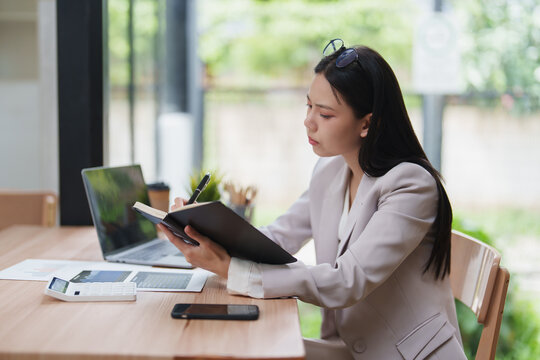 Businesswoman planning tasks and taking notes in notebook