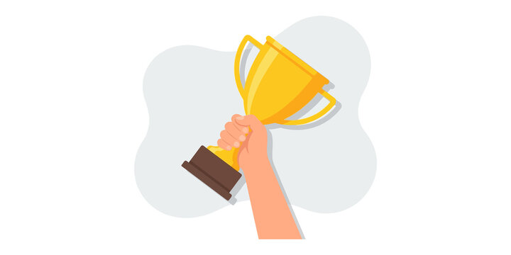 Winner trophy held in human hand featuring gold cup for competition victory or success achievement.