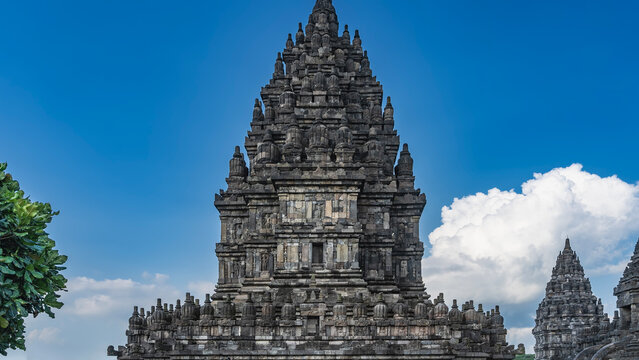 Ancient Hindu architecture. A famous majestic temple Candi Prambanan. A tall stone tower with domes, spires, bas‑reliefs, and ornaments on the walls. Indonesia. Java. Yogyakarta.
