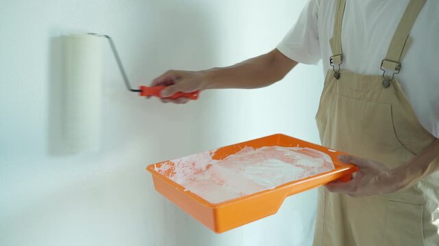 painter man, brush in hand for products to restore and paint the wall, indoor the building site of a house, wall during painting, renovation, painting, contractor, Architect, construction worker