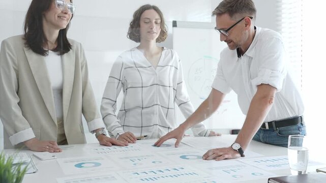 Business team collaborating and analyzing financial charts and graphs during a productive meeting in a modern office. Business people concept