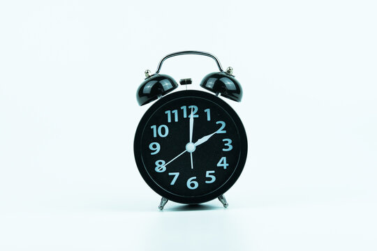 Classic black alarm clock with white numbers showing 2 o&rsquo;clock on white background, symbol of time, punctuality, and daily routine, perfect for concepts of schedule, deadline, and alert.