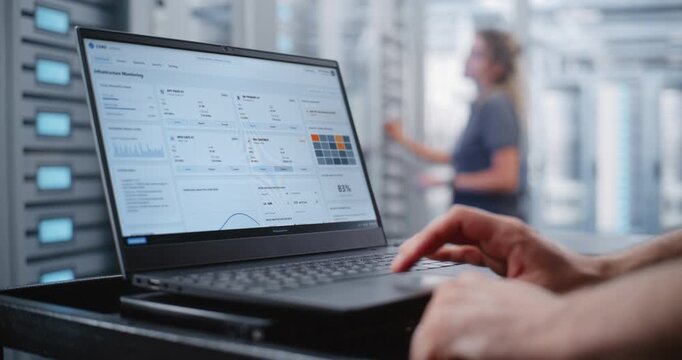 Male Data Center Engineer Responds to Critical Overheating Alert Through Linux CLI, Monitoring Server Health and Entering Emergency Commands While Surrounded by Modern Enterprise Server Racks.