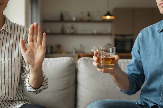 Sober lifestyle concept with a woman rejecting an offer of alcoholic drink