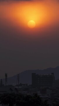 Vertical video - Timelapse of the sun setting behind thick air pollution