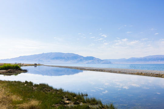 Serene Sayram lake in Xinjiang province China And Mountain Landscape With Calm Reflections Under