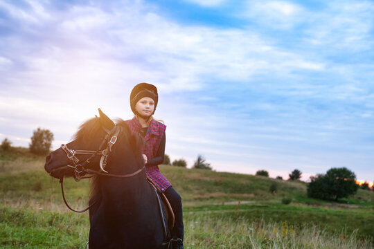 Little Girl Learning to Ride a Horse During a Beautiful Sunny Afternoon in the Quiet Countryside
