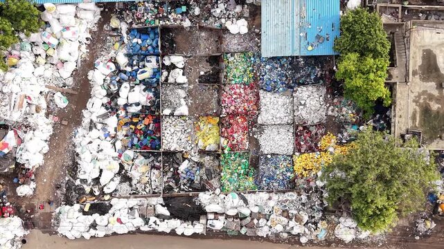 Segregated plastic waste in sorting bays at recycling yard aerial waste management circular economy