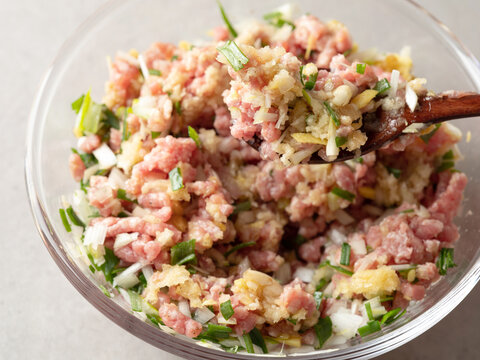Minced meat, vegetables, and dumpling filling in a bowl.