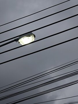 Crisscrossing Power Lines Against Overcast Sky