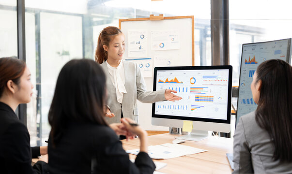 Asian Businesswoman Presenting Financial Data Report to Team