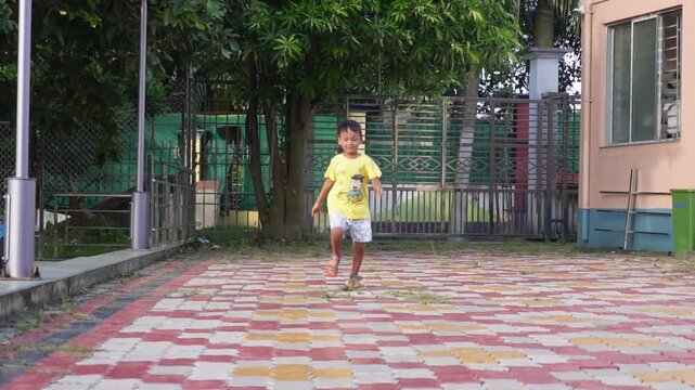 Active young child running outdoors on patterned paved surface