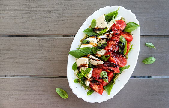 Fresh Caprese Salad with Balsamic Glaze and Basil Leaves. Top view