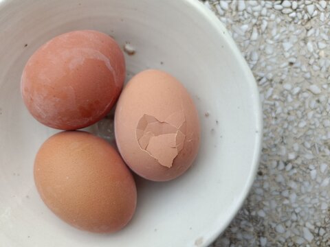Egg protein, boiled eggs in old ceramic cups on a stone table, 3 eggs with some cracked from being knocked