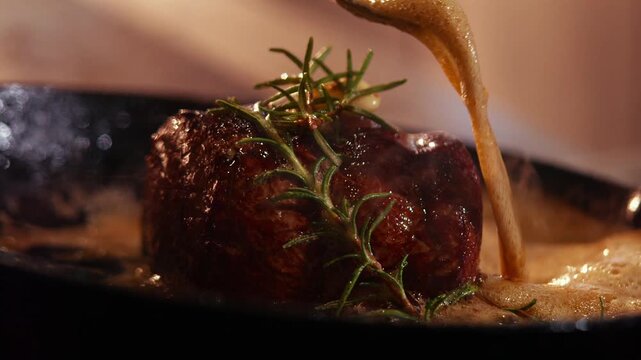 Seared beef tenderloin with rosemary and sauce in a cast iron pan