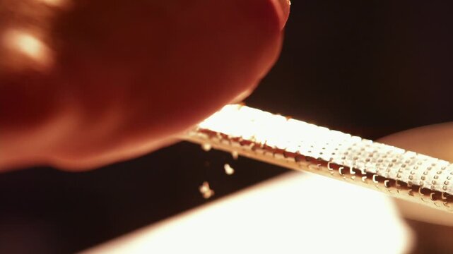 Close-up of a finger sprinkling seasoning onto a dish in a hotel kitchen