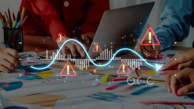 A dynamic team engages in data analysis with colorful stationery and warning signs overlaying graphs, emphasizing collaboration in a modern workspace. Raster