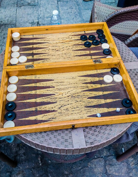 2 Men Playing backgammon at the coffee shop with hearing oriental songs, outdoor activity. using Dices to get number of movements of checkers and following the game rules, selective focus, Cairo Egypt
