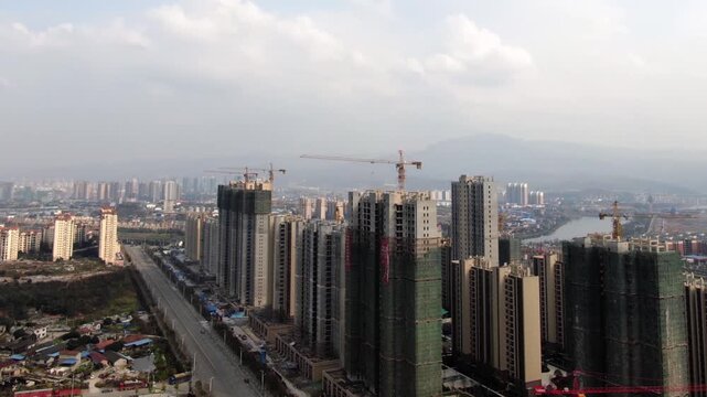 Aerial View of City Skyline with High-Rise Buildings Under Construction and Tower Cranes