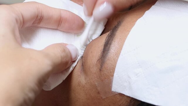 Preparing eyelashes for extensions in a beauty salon, close up