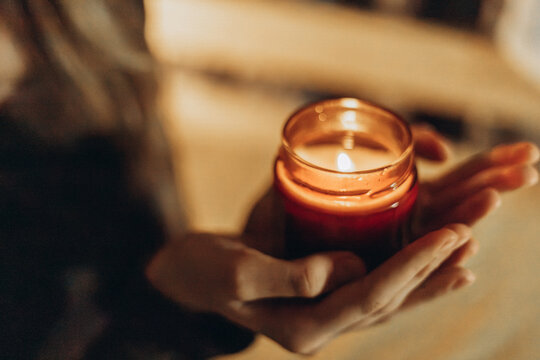 Girl holding a scented candle in warm evening light