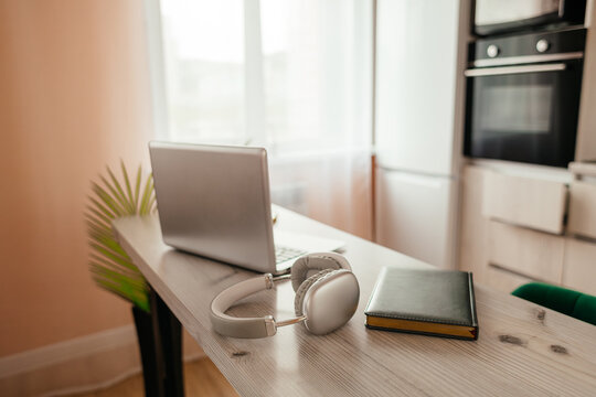 Laptop and headphones on desk in modern home office
