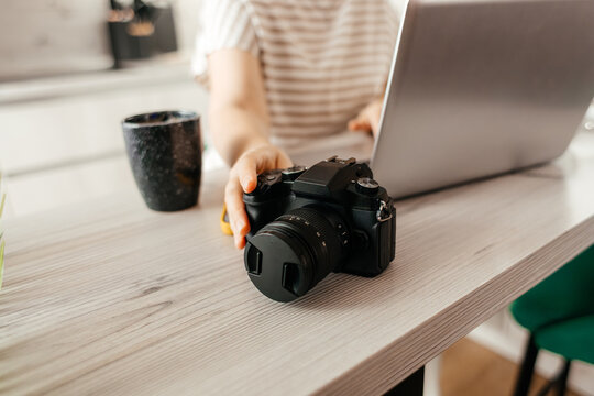 Female photographer work remotely with camera and laptop