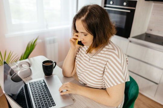 Woman work remotely on laptop and smartphone at home