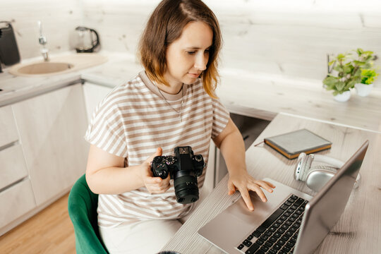 Female photographer edit images on laptop during remote work