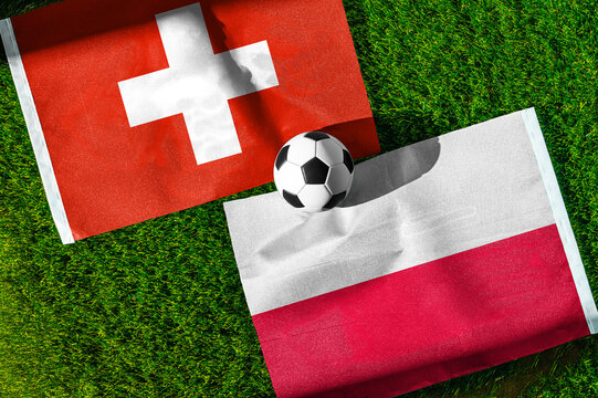 Switzerland vs. Poland football match. National flags on green grass with soccer ball in the middle. Football background for international match.