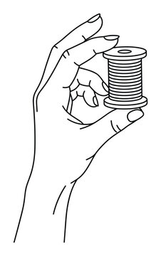 Hand holding sewing thread spool bobbin for textile manufacture.