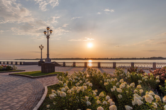 Beautiful riverside promenade with flowers at sunset
