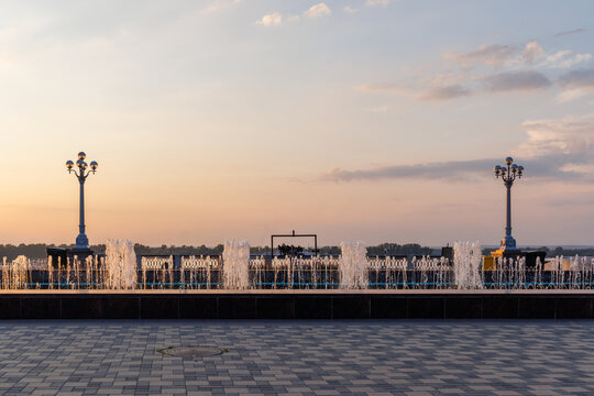 Modern fountains on landscaped riverside promenade