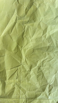 Wrinkled light green paper texture with vertical fold line for vintage stationery designs.