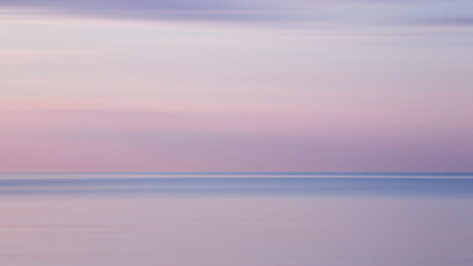 Obraz premium Blurred background sea and sky at sunrise. The sea and the sky are pearly. Beautiful backdrop for your design.
